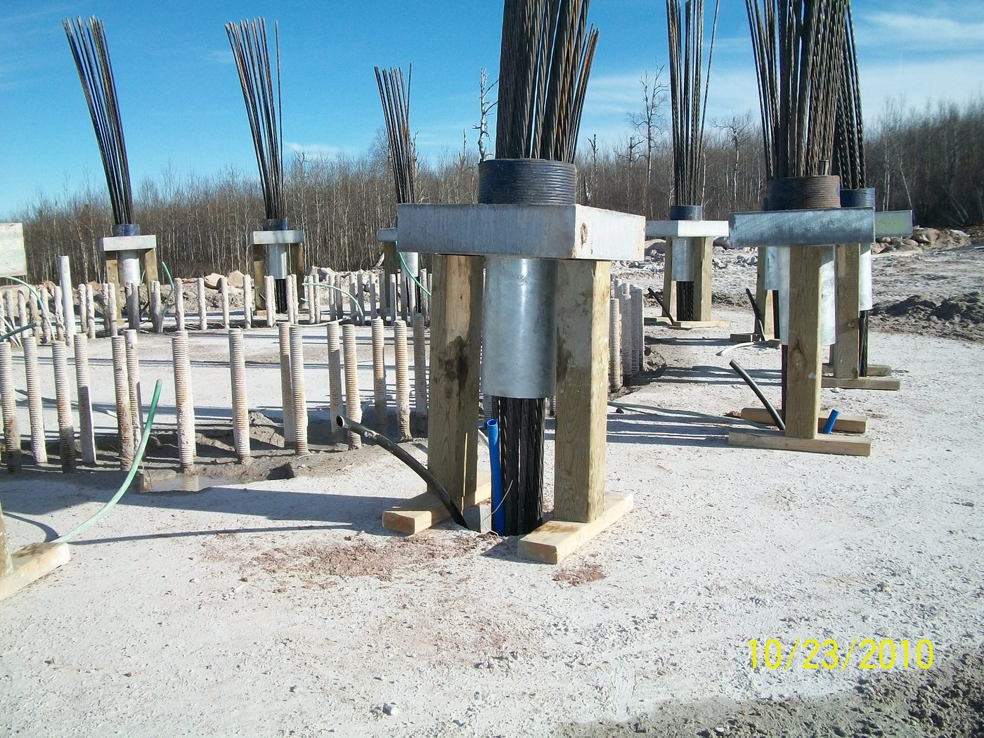Rock anchor tendons and anchor heads projecting from concrete pedestals on a prepared site.